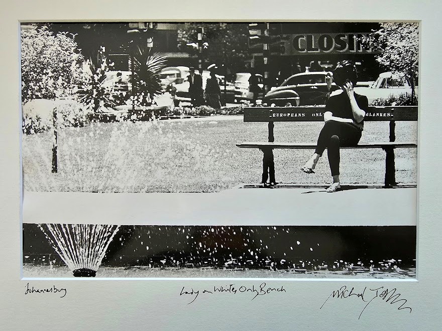 Johannesburg 1960s, lady sitting on whites only bench in a park near a fountain by Michael Joseph