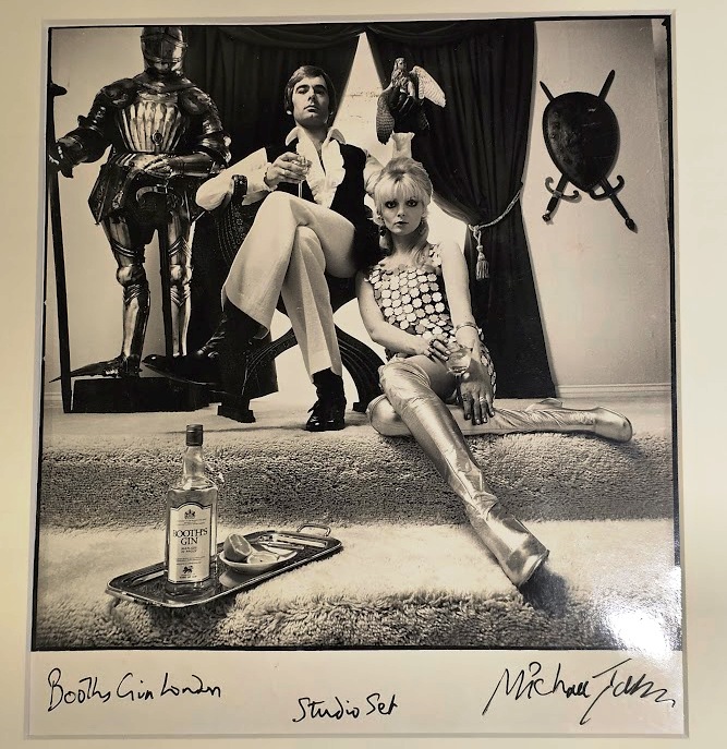 Couple drinking Booths gin next to knight in shining armour and shield by Michael Joseph