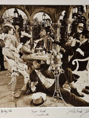 Man drinking under the table, group of people drinking champagne in period costume, advert test print by Michael Joseph