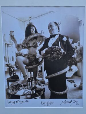 Butler presenting roses to snake charmer, Grenzquell lager ad, sepia tone by Michael Joseph