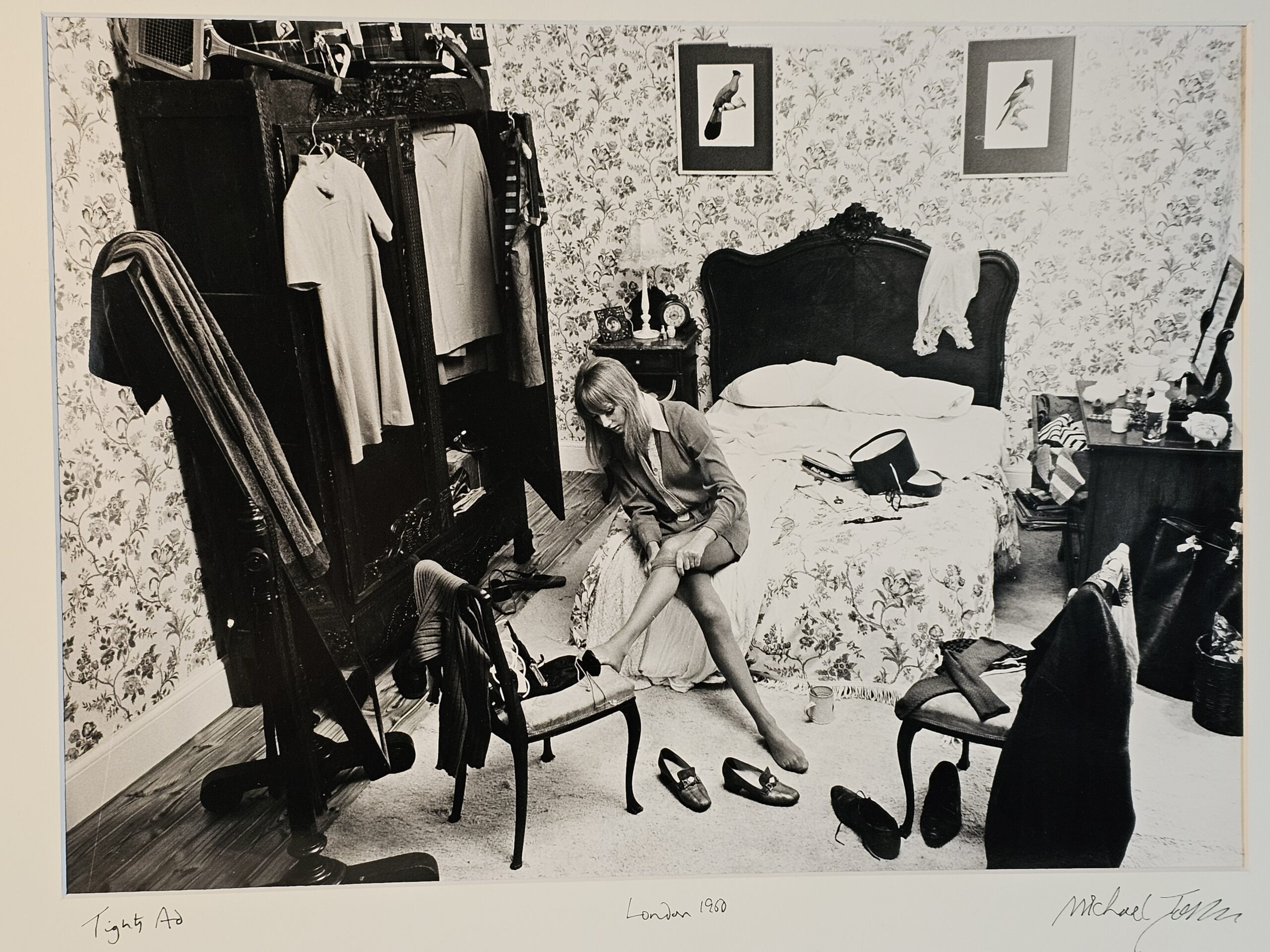 Girl pulling up tights on bed, flowery wallpaper, tennis racket and wardrobe, students of the sixties authentic vintage darkroom print