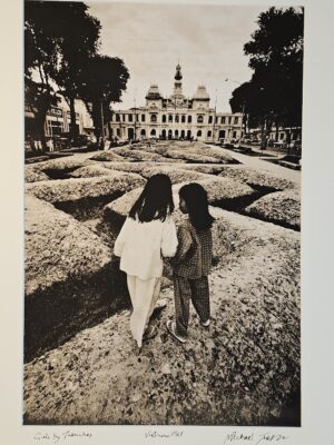 South Vietnam pair of girls playing near trenches in flip-flops, in front of luscious palace by Michael Joseph