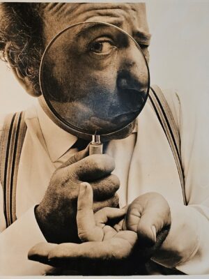 Sid James wiggling - his finger through his flies - full height studio portrait by Michael Joseph