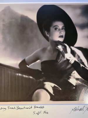 Mannequin qui porte un bracelet par Sarah Bernhardt, assise sur chaise-longue avec montagnes derrière par Michael Joseph