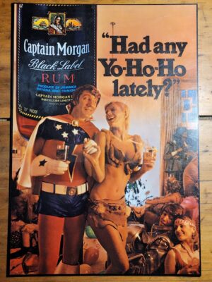 Had any yo ho ho lately - super-hero and cave girl - Captain Morgan Rum laminated advert by Michael Joseph