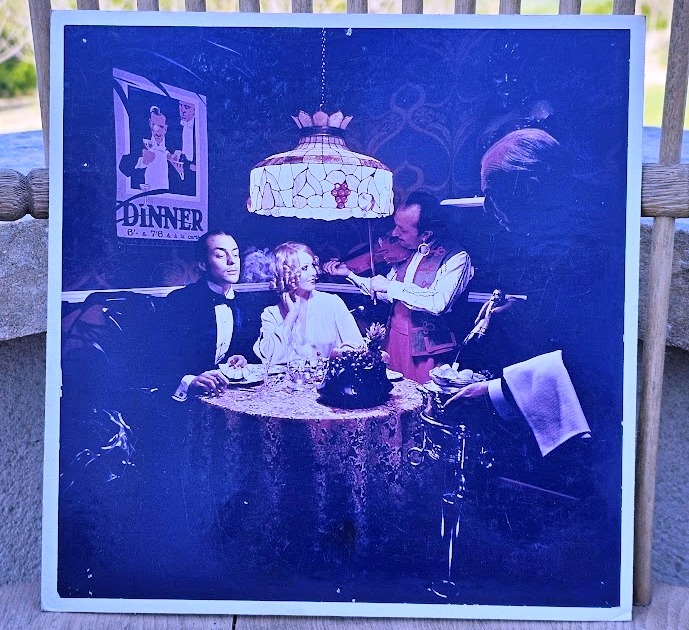 Colour print of fiddler and couple dining for UK Shell Mex and BP oil-fired central heating ad by Michael Joseph