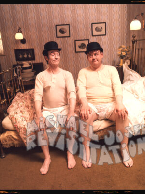 Laurel et Hardy sur un lit en laiton, publicité pour chaussettes, Collection Funky couples, Photographie publicitaire londonienne Carte postale de Michael Joseph