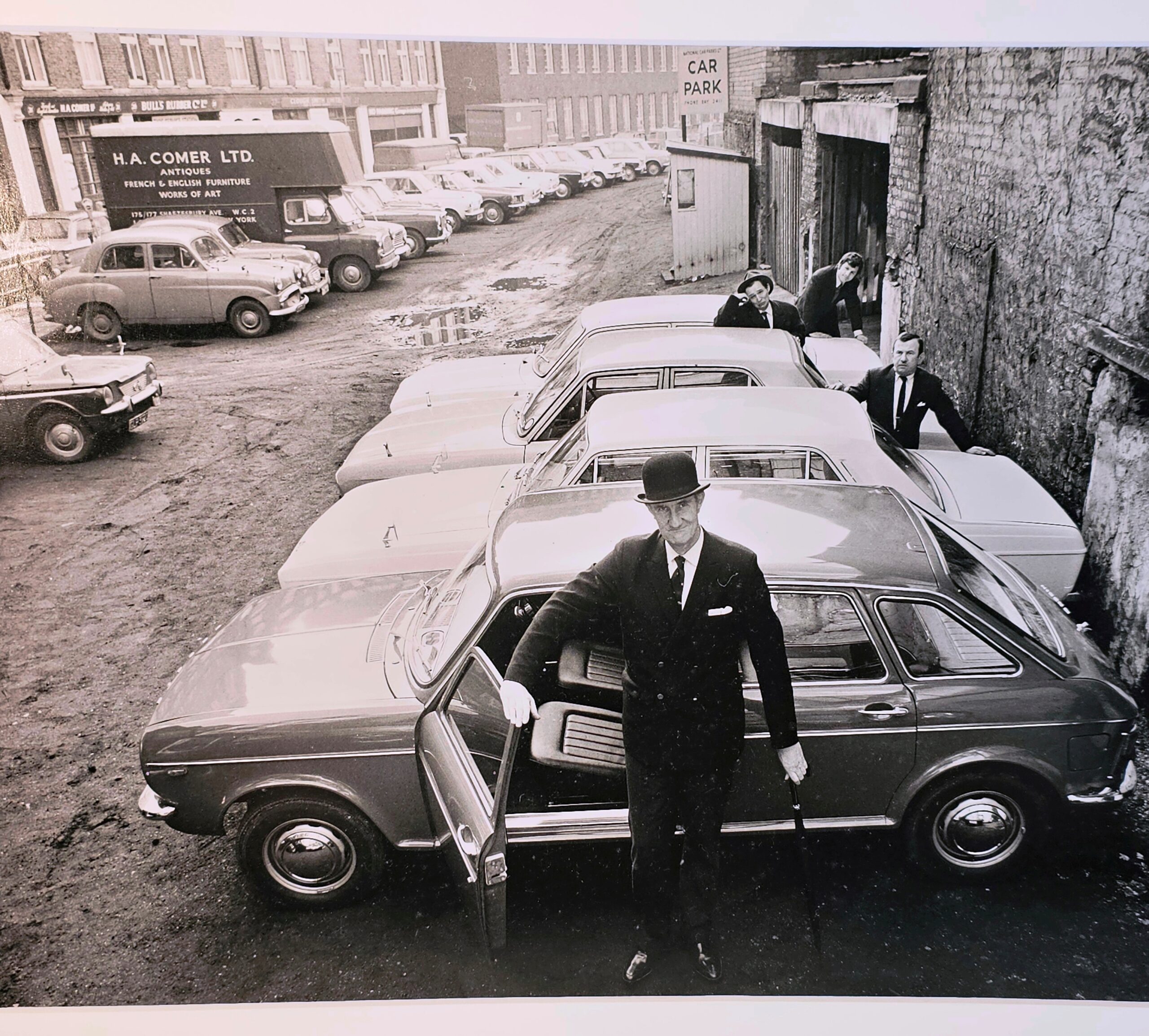 Concessionnaire automobile sur le parvis avec chapeau melon, tirage d'essai authentique en chambre noire